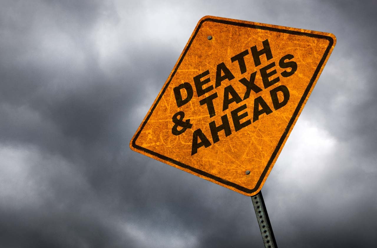 street sign saying "death & taxes ahead"